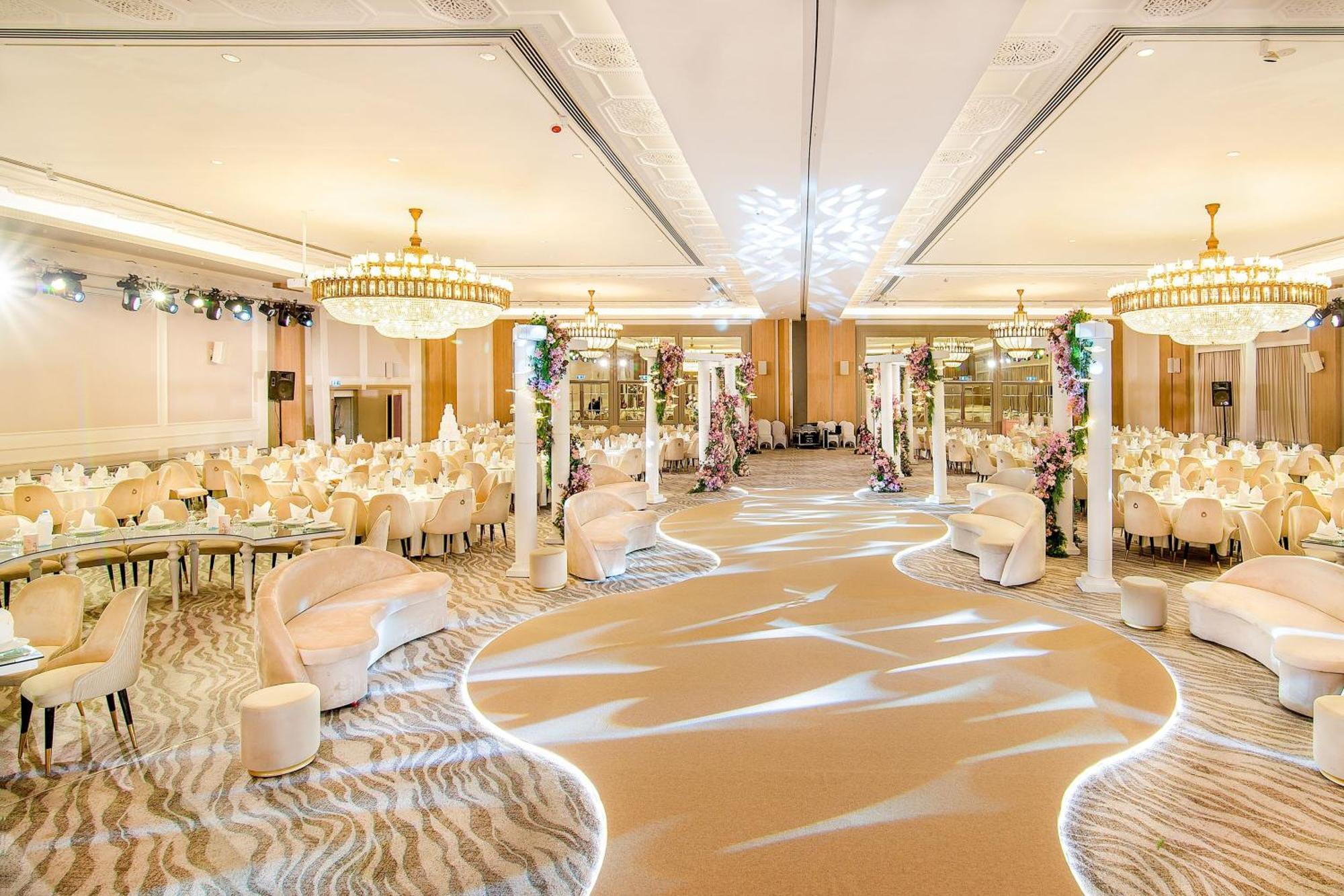 Sheraton Abu Dhabi Hotel&Resort Esterno foto The photo shows an elegant banquet hall or event space. The room is decorated with soft, neutral tones and features several round tables covered in white tablecloths, each set with elegant dinnerware. There are plush white chairs surrounding the tabl