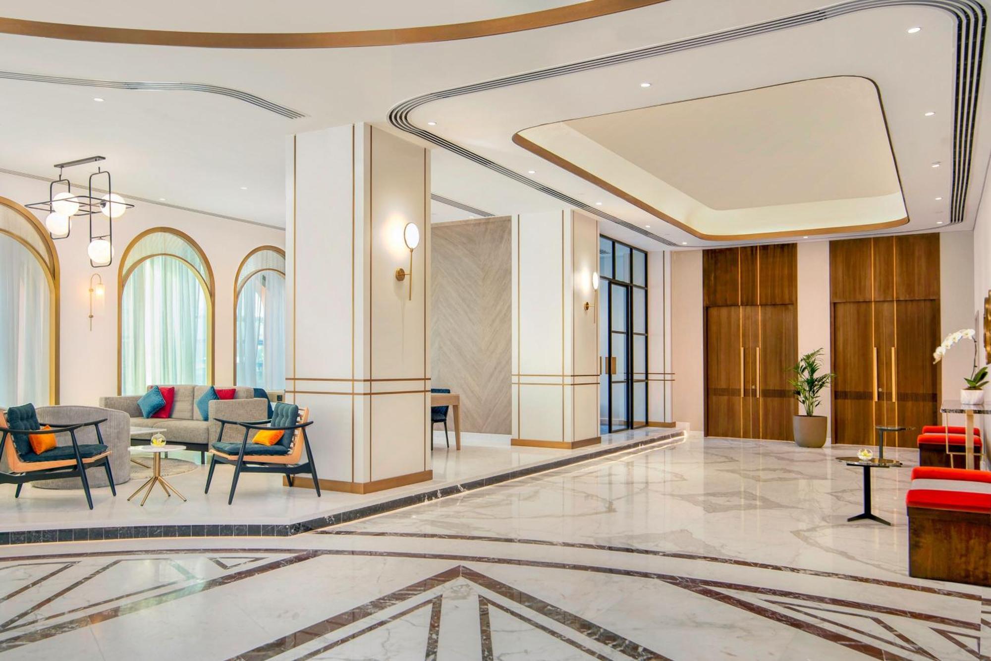 Sheraton Abu Dhabi Hotel&Resort Esterno foto The photo shows a modern lobby area with elegant design elements. There are large windows allowing natural light to illuminate the space, which features a marble floor with a geometric pattern. On one side, there are comfortable seating arrangements 