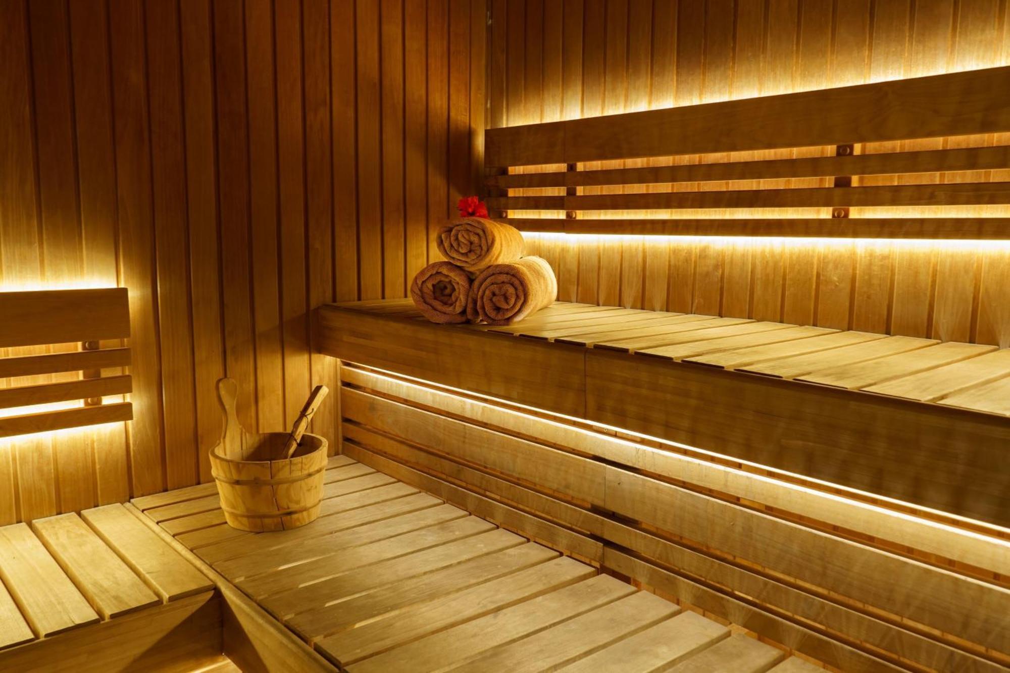 Sheraton Abu Dhabi Hotel&Resort Esterno foto The photo depicts a wooden sauna interior. The walls and benches are made of wood, creating a warm and natural atmosphere. There are three rolled towels placed neatly on a bench, and a small wooden bucket with a ladle is situated nearby, likely for p